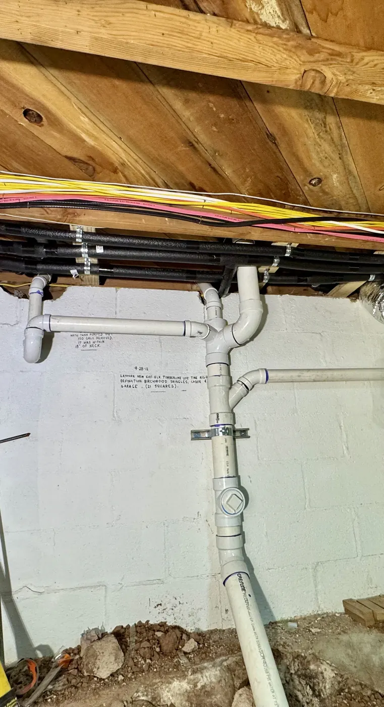 New PVC drain and vent piping installed in a crawlspace
