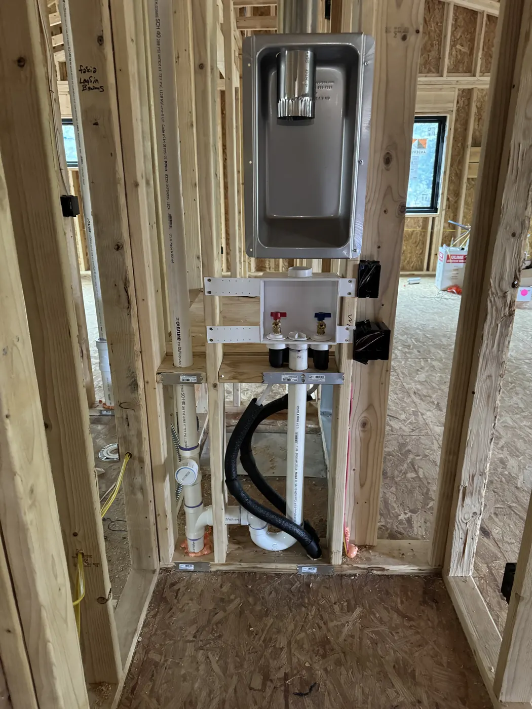 Framed shower wall with a new mixing valve, supply lines and drain roughed in before tile